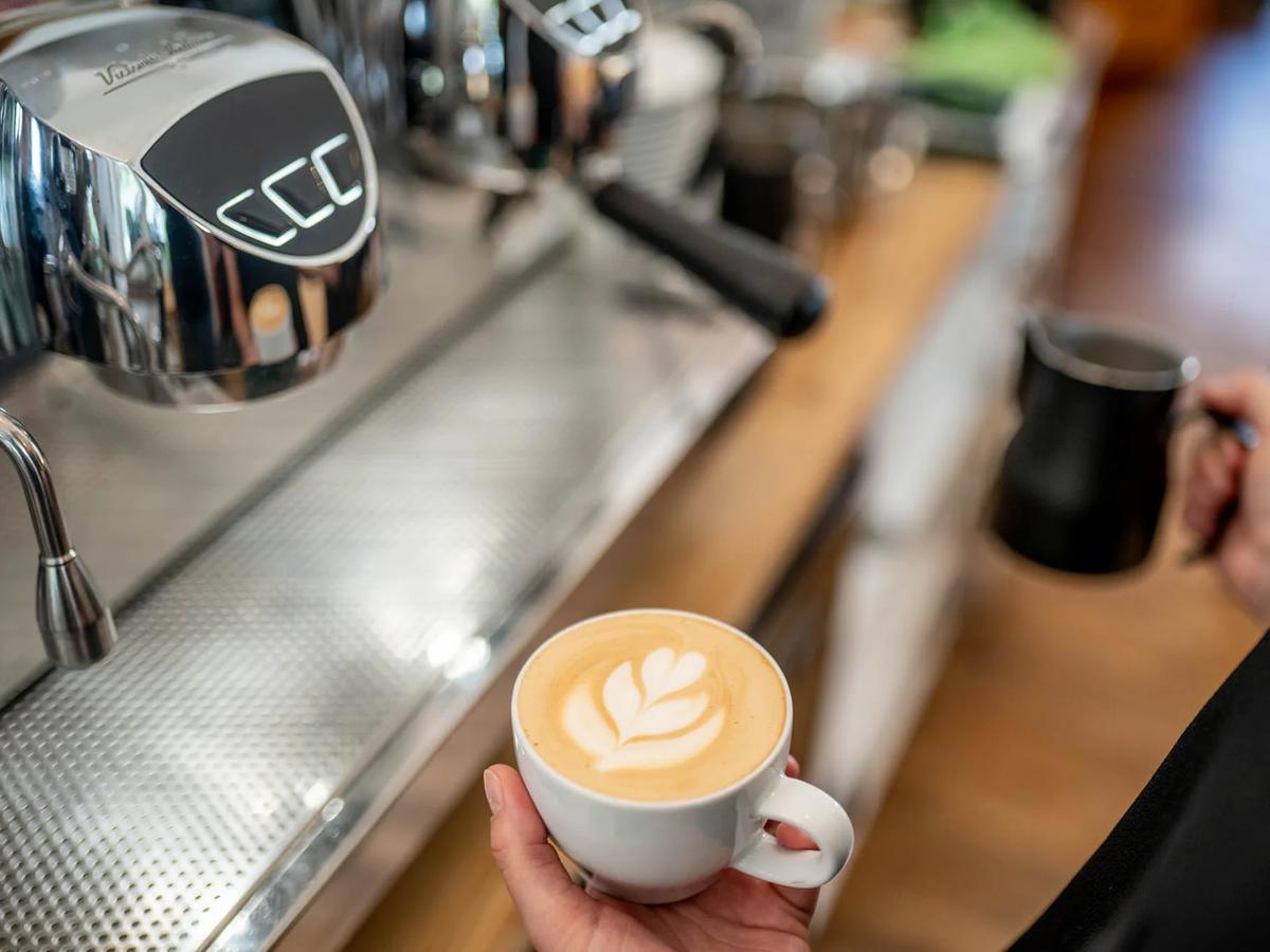Cappuccino mit Latte Art vor der Siebträgermaschine