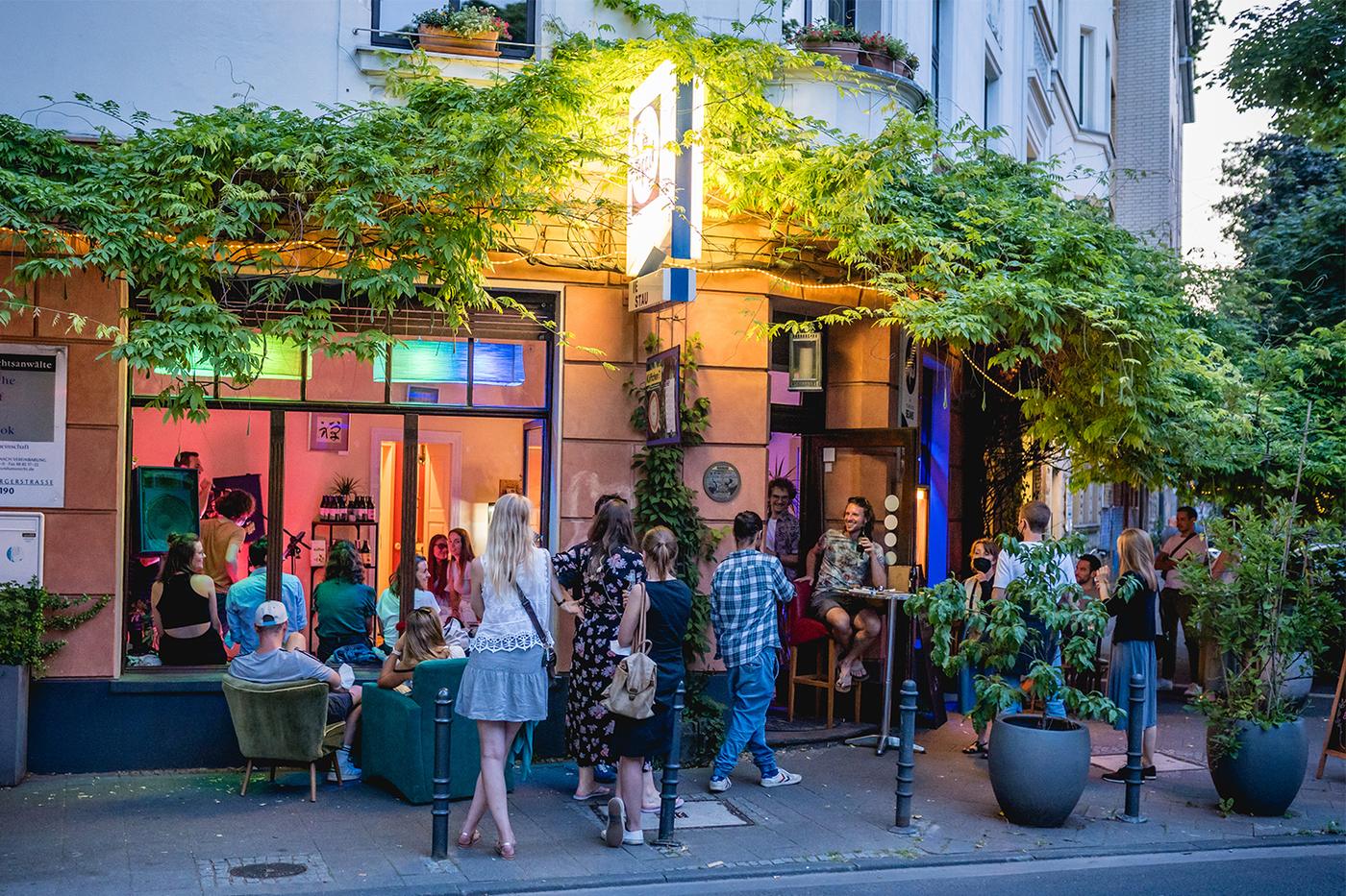 Zwei Gäste lachen abends an einem Tisch im Café